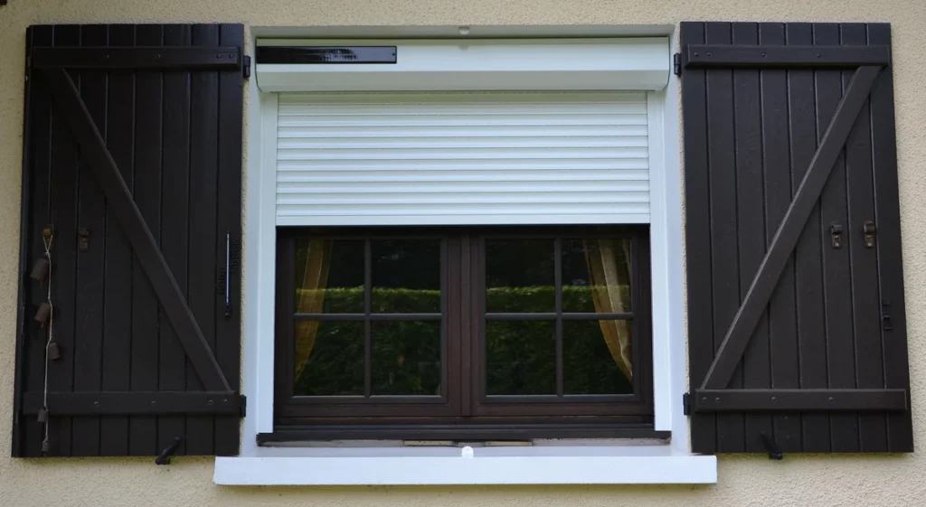 Volet roulant solaire blanc sur mesure, coffre à pan coupé avec capteur solaire, fenêtre à petits carreaux